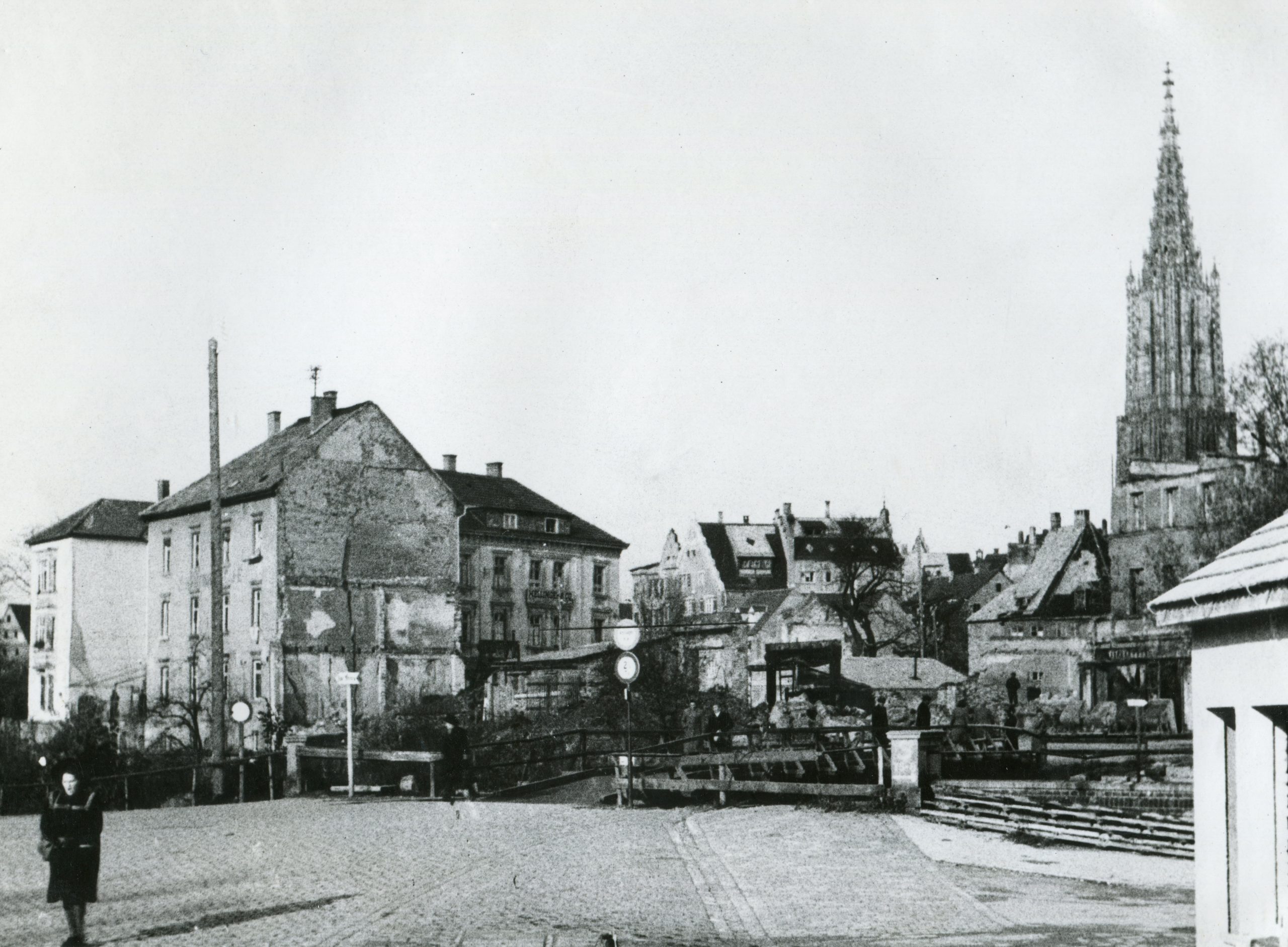 Großteils schon abgeräumte Ruinen auf der Insel mit provisorischer Holzbrücke. Die Häuser der linken Bildhälfte stehen heute noch. 1948, StANU